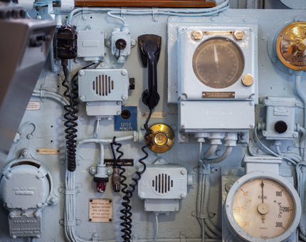 A detailed image of dials, gauges, speakers and phones on the Bridge. 