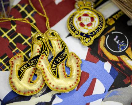 A selection of hanging ornaments. A Britannia crest and two anchors.