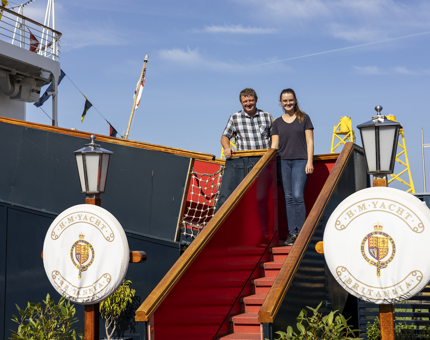 Two Visitors Pose For A Photo On Britannia's Royal Brow in Leith. 
