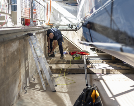 A maintenance man is preparing to add a filtration system in the Royal Barge pond.