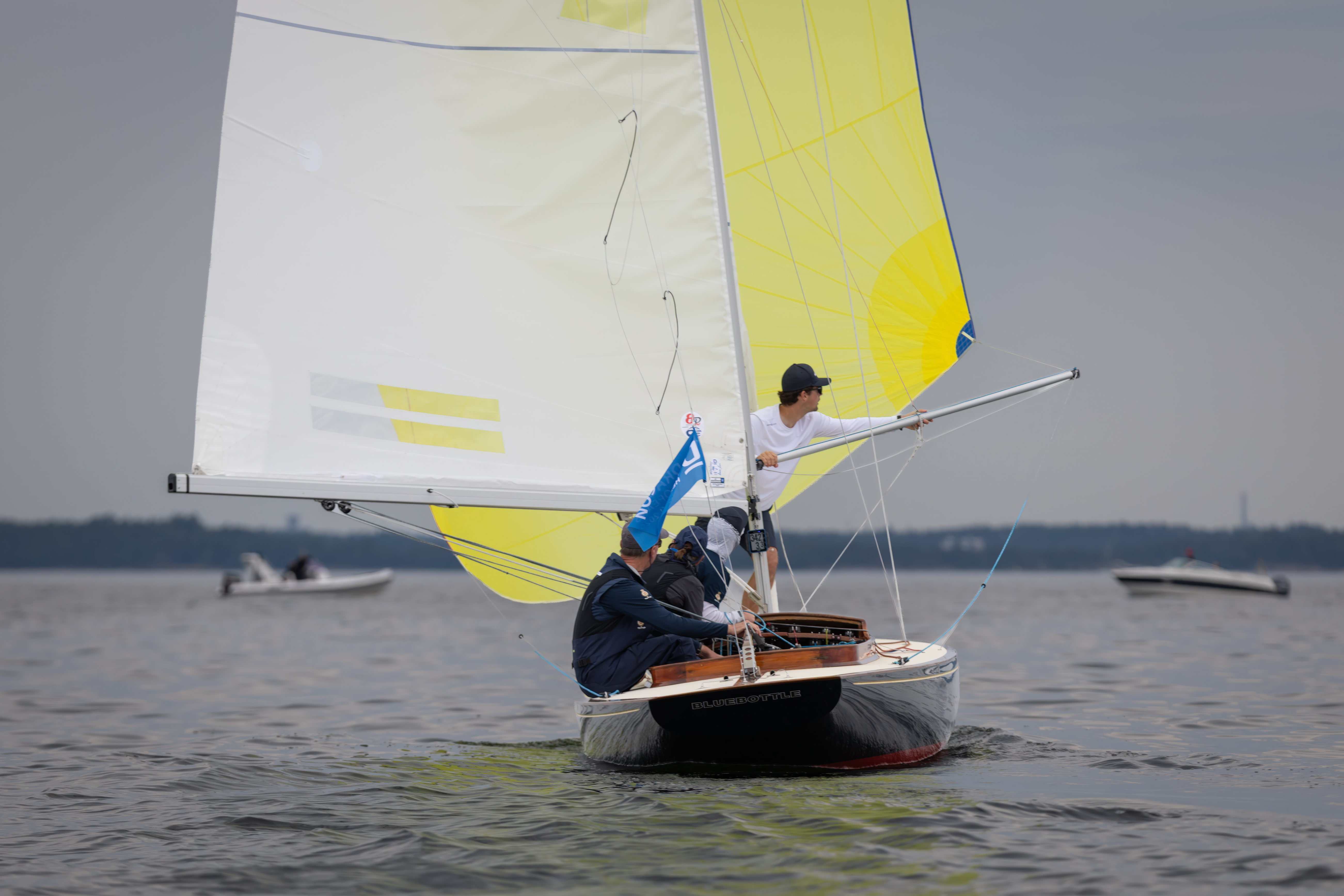 A crew sailing on a sailboat in the water