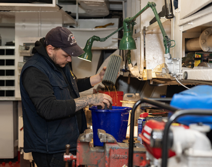 An oil filter from the Royal Barge being cleaned by a Maintenance team member.