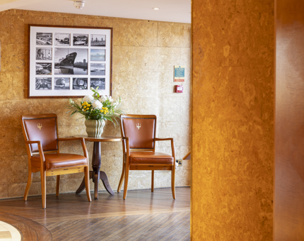 Two chairs are positioned on either side of a small table in Fingal Hotel's Reception area. 