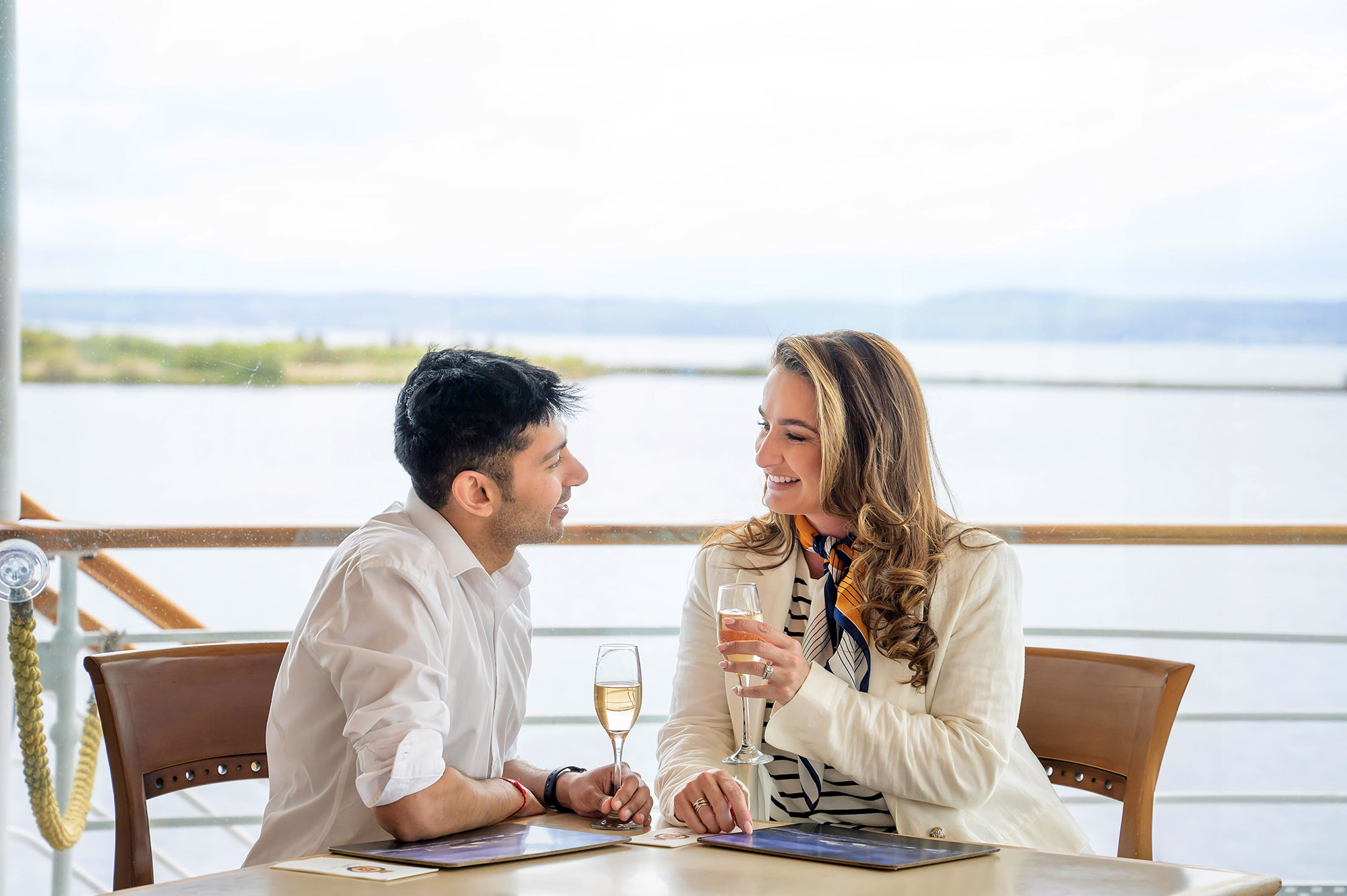 Two visitors in the Royal Deck Tearoom on Britannia in Leith drinking Champagne.
