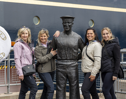  Visitors posing for a photo with the statue of Norrie, the longest serving Yachtsman on Britannia. 