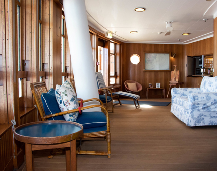 Interior of The Sun Lounge with bamboo chairs and chintz floral sofa.