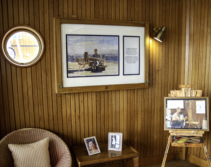 A painting hanging on the wall in the Sun Lounge of The Duke of Edinburgh and a painting sitting on an easel of the artist Edward Seago.