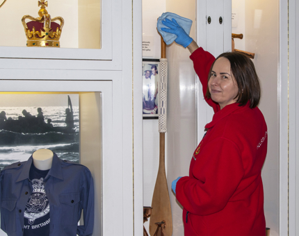 A Housekeeper cleaning the oar in the Visitor Centre which was used to stir the Christmas pudding during Royal service.