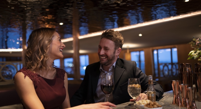 Man and woman sit enjoying drinks at The Lighthouse Restaurant & Bar at Fingal. 
