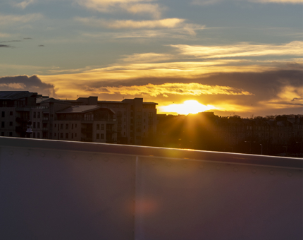 The view from The Bridge with a golden sunset in the sky with clouds.
