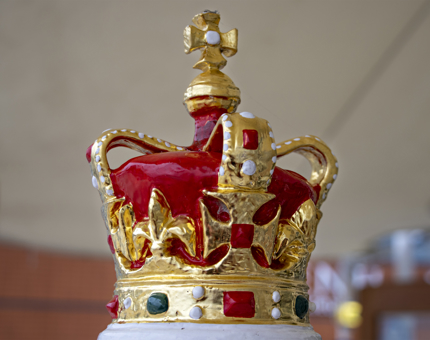 A close-up detail of the crown on top of the decorative compass binnacle.