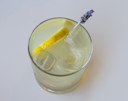 A cocktail for Mother's Day containing Britannia Gin, and a slice of lemon and a sprig of lavender.