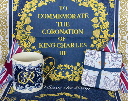 A selection of Coronation souvenirs including a tea towel, mug and set of coasters.