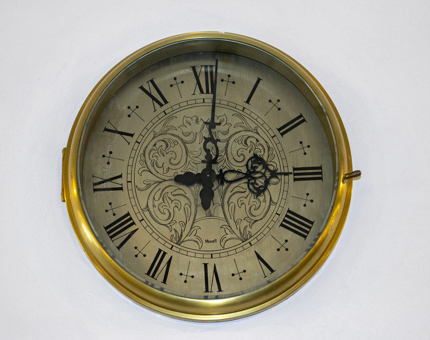 A close-up of an ornate clock displaying roman numerals at 3.01pm, the last time that Queen Elizabeth II stepped ashore from Britannia.