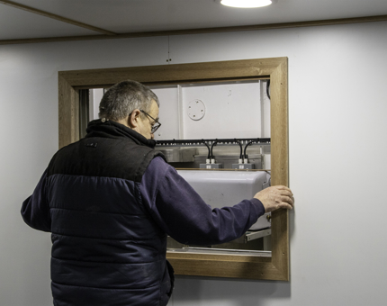 A man making a frame in the wall of the former Junior Rates' Dining Hall.