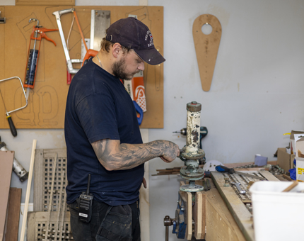 A Maintenance team member is stripping down a part from the Royal Barge. 