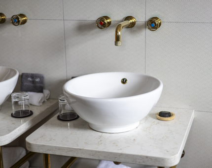 A white sink with brass fittings aboard Fingal. 