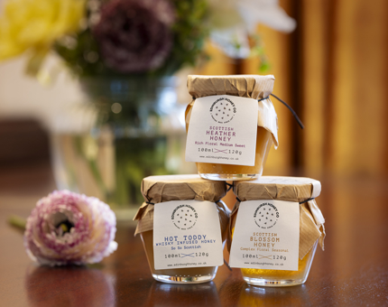 Three jars of honey stacked. 