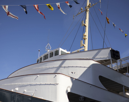  A view of Britannia's bridge from the ground up. There are colourful dress flags flying above the ship.