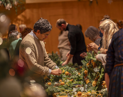 Aboard Fingal Hotel, people are participating in a Christmas wreath making workshop in the Ballroom. 