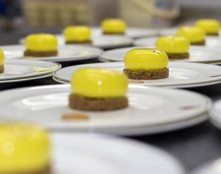 Plates lined up on the Galley worktop with lemon cheesecakes on them.