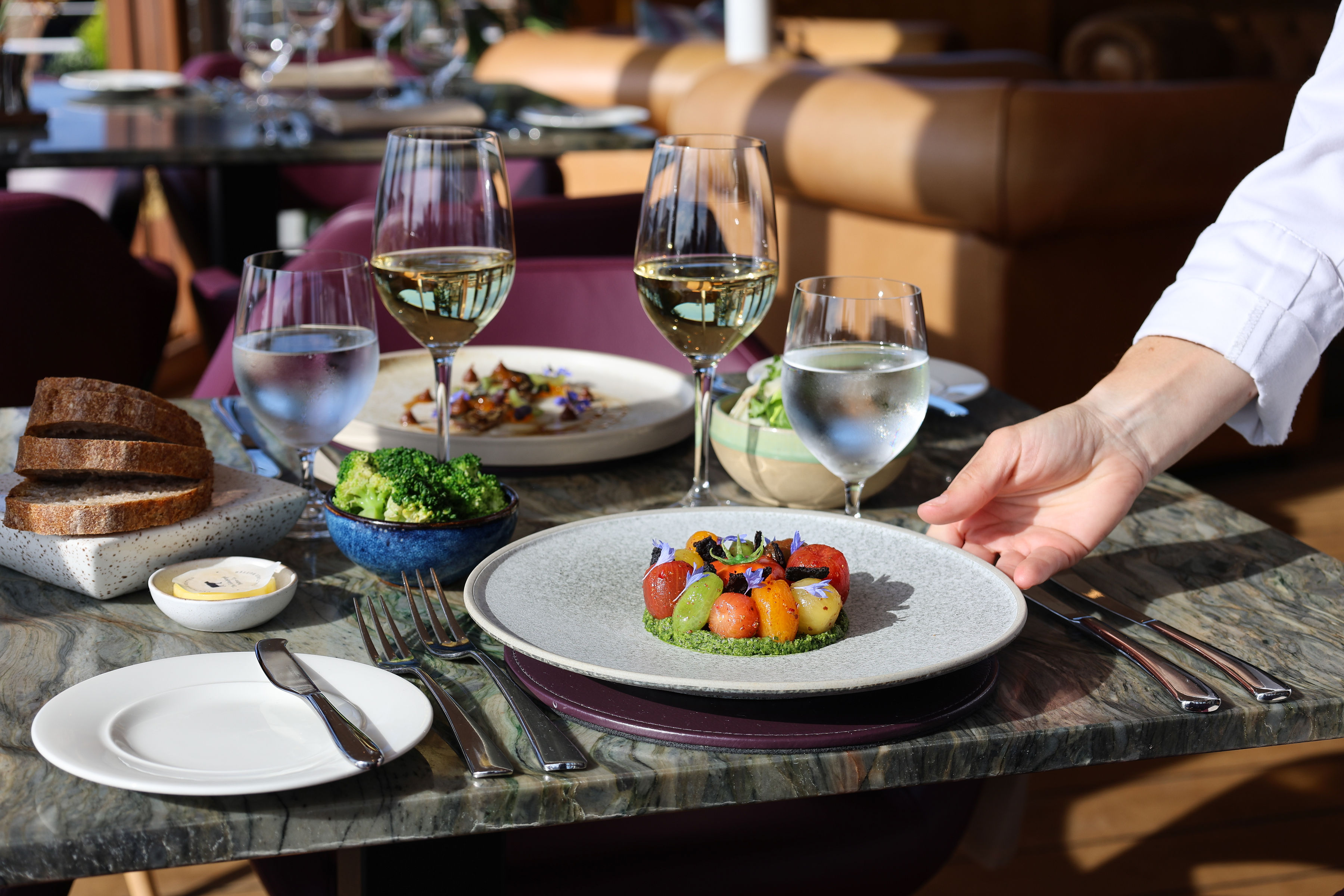 A chef placing a dish made from tomatoes onto the table in The Lighthouse Restaurant in Leith.