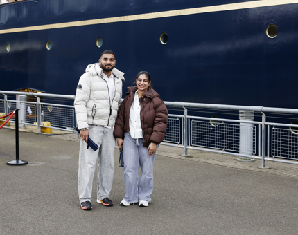 A man and woman standing on Britannia's quayside in Leith posing for a photo. 