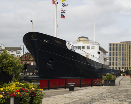 A view of Fingal Hotel from the Quayside. There are planters with flowers in the foreground. 