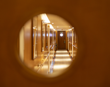 A view of the cabin corridor through a Porthole aboard Fingal Hotel. 