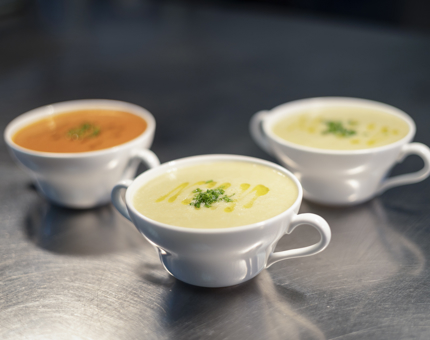 Two bowls of Cullen skink soup and a bowl of roasted red pepper & vine plum tomato soup in the onboard Galley. 