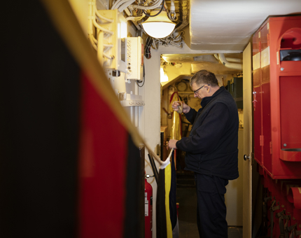 On board Britannia a man is organising dress flags. 