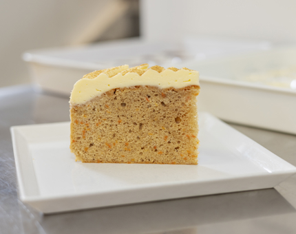 A slice of carrot cake sitting on a white plate.
