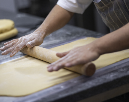 A chef's hands are rolling out pastry on the bench in the Galley aboard Britannia in Leith. 