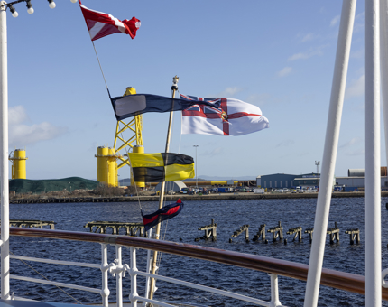 In the Port of Leith, there are flags flying from the deck of Britannia. 