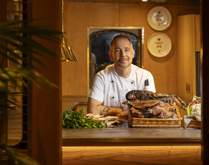 A Chef is standing behind the bench in the Bridge Galley aboard Fingal in the Port of Leith. 