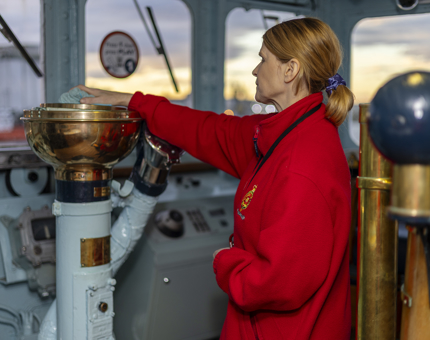 A Housekeeper is polishing the brass in the Bridge aboard The Royal Yacht Britannia. 