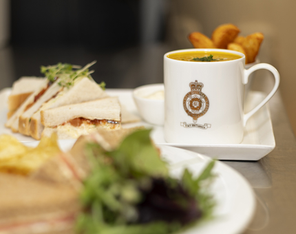 A tray with a cocktail with a white straw and lime wedge. There are also tray the have coffees on them.