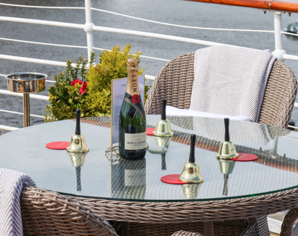 Table and chairs, four bells and a bottle of Champagne aboard Fingal to celebrate the opening of the Moët Deck