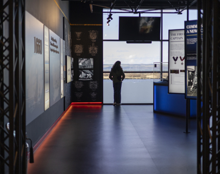 The entrance to Britannia's Visitor Centre, there is a person looking out of the windows to the Port of Leith. 