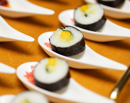 A close up of sushi canapes on a tray. 