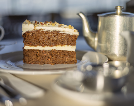 A slice of carrot cake and a pot of tea on a table in the Royal Deck Tearoom. 