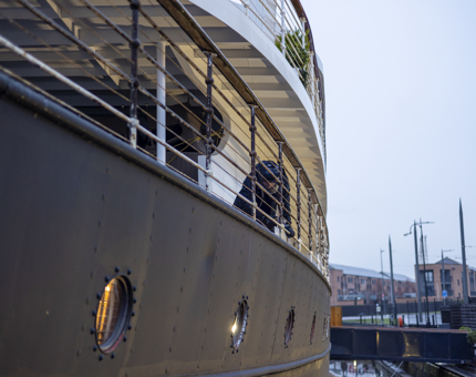 The side of Fingal in Leith, a maintenance man is removing paint from the railings. 