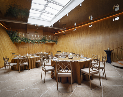 Tables set for an evening event in Fingal's Ballroom. The table cloths are gold. 