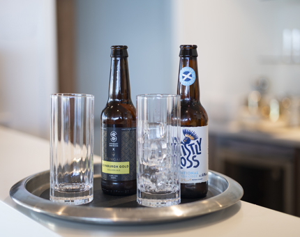 Two bottles of beer and two glasses on a silver tray in the Tearoom. 