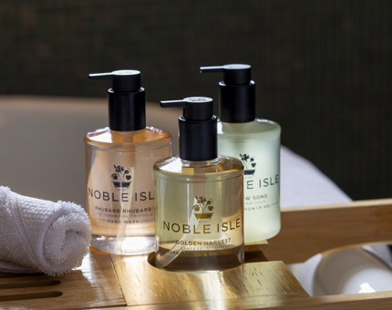 Three bottles of Noble Isle bath & body products. 