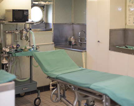 The Operating Theatre aboard Britannia in Leith. There is an operating bed with a green sheet on it. 