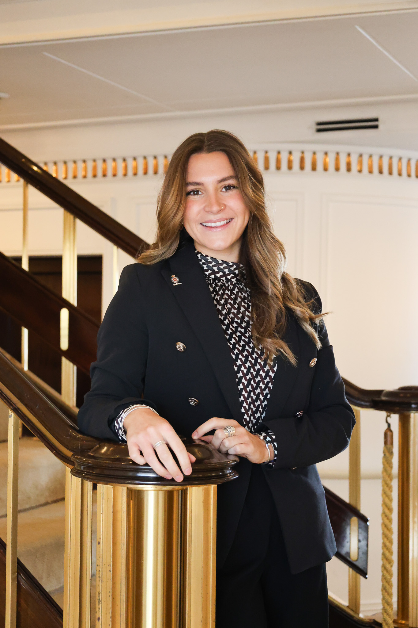Headshot of a woman standing on a staircase.