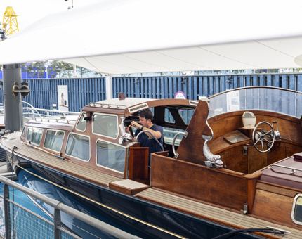 A Maintenance man is working on the Royal Barge on Britannia's quayside. 