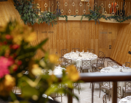 A view of Fingal's Ballroom from the gallery bar, there are flowers in the foreground. 