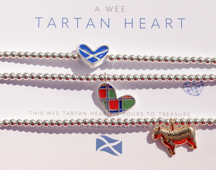  A Range Of Scottish Bracelets From Joma Jewellery, there are charms on the bracelet of a Highland Cow, Tartan heart and heart with a Scottish flag on it. 